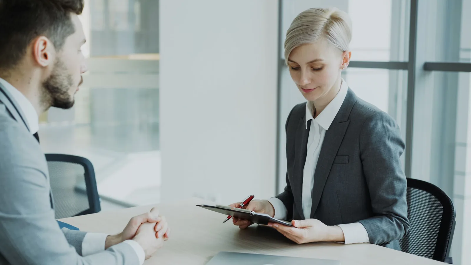 Two professionals discussing pay strategy in a bright office
